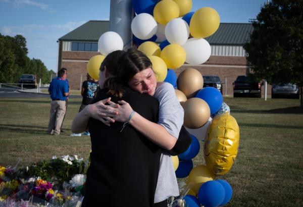 Students gather at a makeshift memorial outside Apalachee High School.