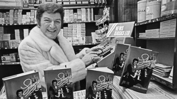 Liberace with his book