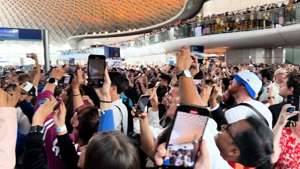 Harry Potter fans pointing their phones at the King's Cross departure board expecting a Hogwarts Express announcement.