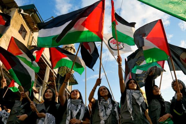 Women wave Palestinian flags during a rally in solidarity with the Palestinian people in Gaza, at Bourj al-Barajneh Palestinian refugee camp, in Beirut, Lebanon, Wednesday, Oct. 11, 2023.