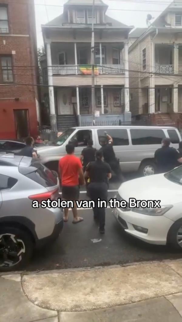 Cops and a pedestrian surrounding a stolen van in the Bronx