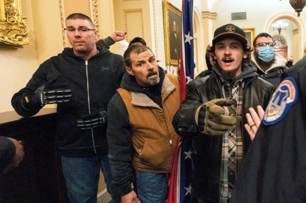 Michael Sparks, left, and Kevin Seefried, second from left, as they and other rioters loyal to President Donald Trump are confronted by U.S. Capitol Police officers outside the Senate Chamber inside the Capitol in Washington, Jan. 6, 2021
