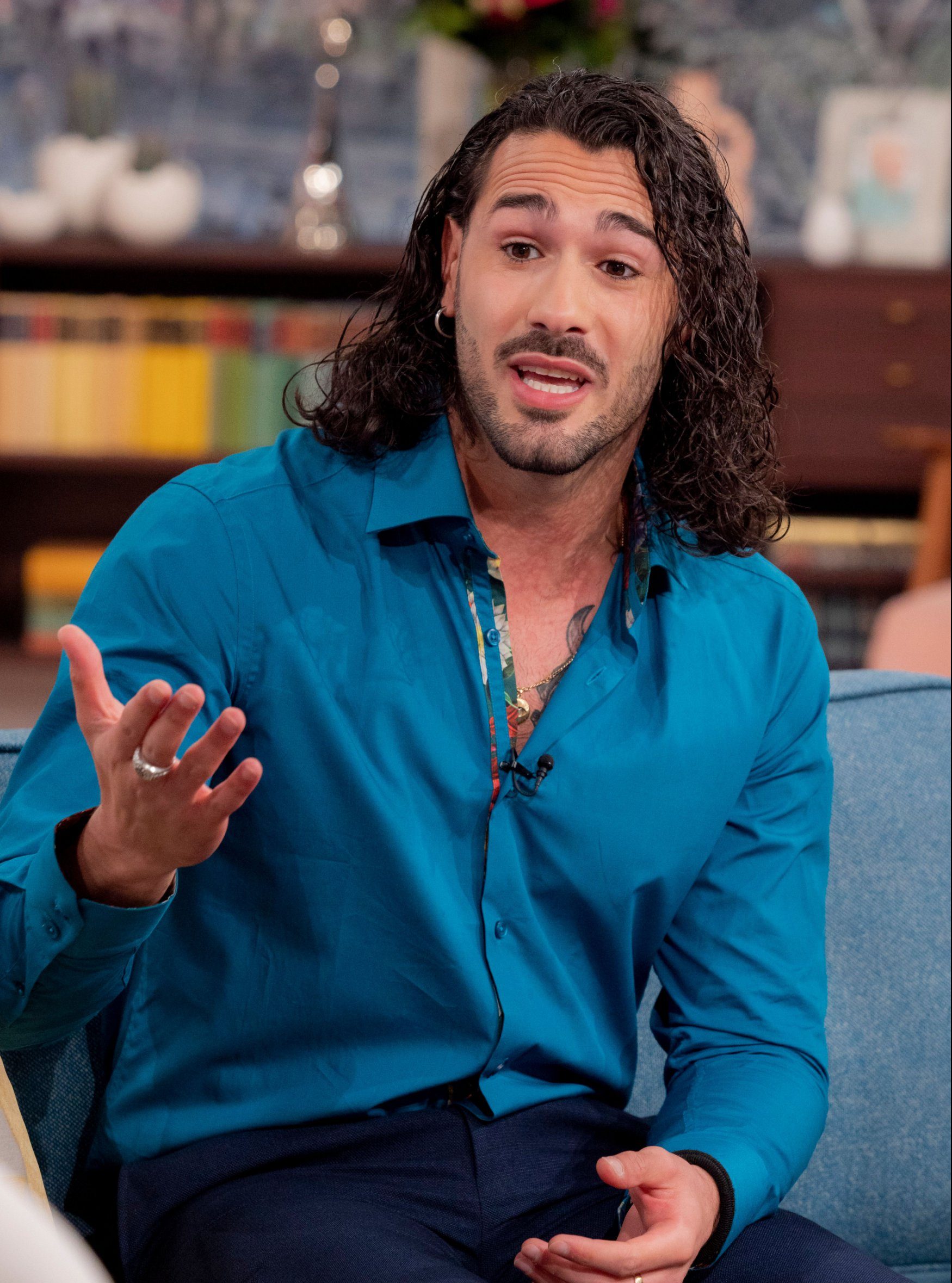 Graziano Di Prima gesturing with his hand while speaking during a TV appearance