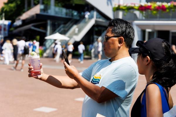 A fan photographing Honey Deuce cocktails at the 2024 US Open Championships in Queens, New York