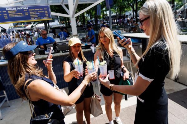 A group of fans cheers with their Honey Deuces.