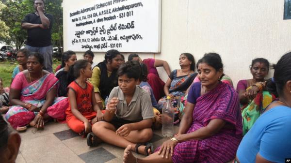 Relatives of the victims killed in a fire triggered by an explosion at the Escientia Advanced Sciences Private Ltd., a pharmaceutical company, sit outside the factory, in Atchutapuram, Andhra Pradesh state, India, Aug. 22, 2024. 