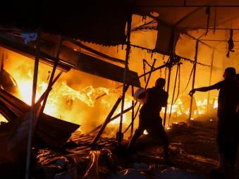 People attempt to extinguish a fire at the site of an Israeli strike on tents sheltering displaced people, amid the Israel-Hamas conflict, in Deir Al-Balah in the central Gaza Strip, October 14. (Reuters)