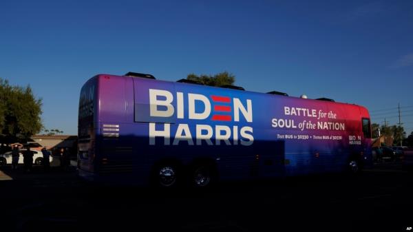FILE - Democratic presidential candidate former Vice President Joe Biden and Democratic vice presidential candidate Sen. Kamala Harris, ride on a bus in Phoenix, Arizona, Oct. 8, 2020, on a small business bus tour. 