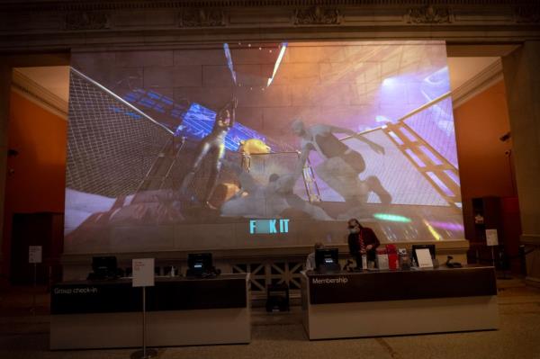 Screen behind Met ticket counter showing images from "Metta Prayer"