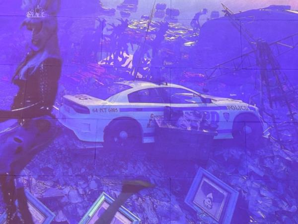 A image of a trashed out NYPD patrol car in a Met art exhibit.