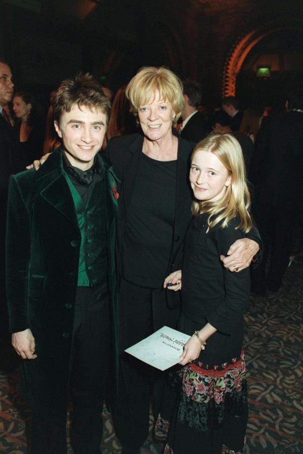 Daniel Radcliffe with Maggie Smith and her granddaughter in 2005, smiling.