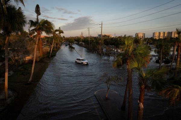 A drone view shows a car driving through a flooded street following Hurricane Milton in Siesta Key, Florida, U.S., October 10, 2024.
