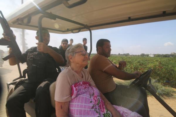 Palestinians transport a captured Israeli civilian, center, from Kibbutz Kfar Azza into the Gaza Strip on Saturday, Oct. 7, 2023.