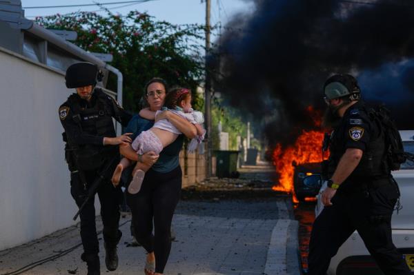A Israeli woman and child getting evacuated after a rocket strike n Ashkelon on October 7, 2023.