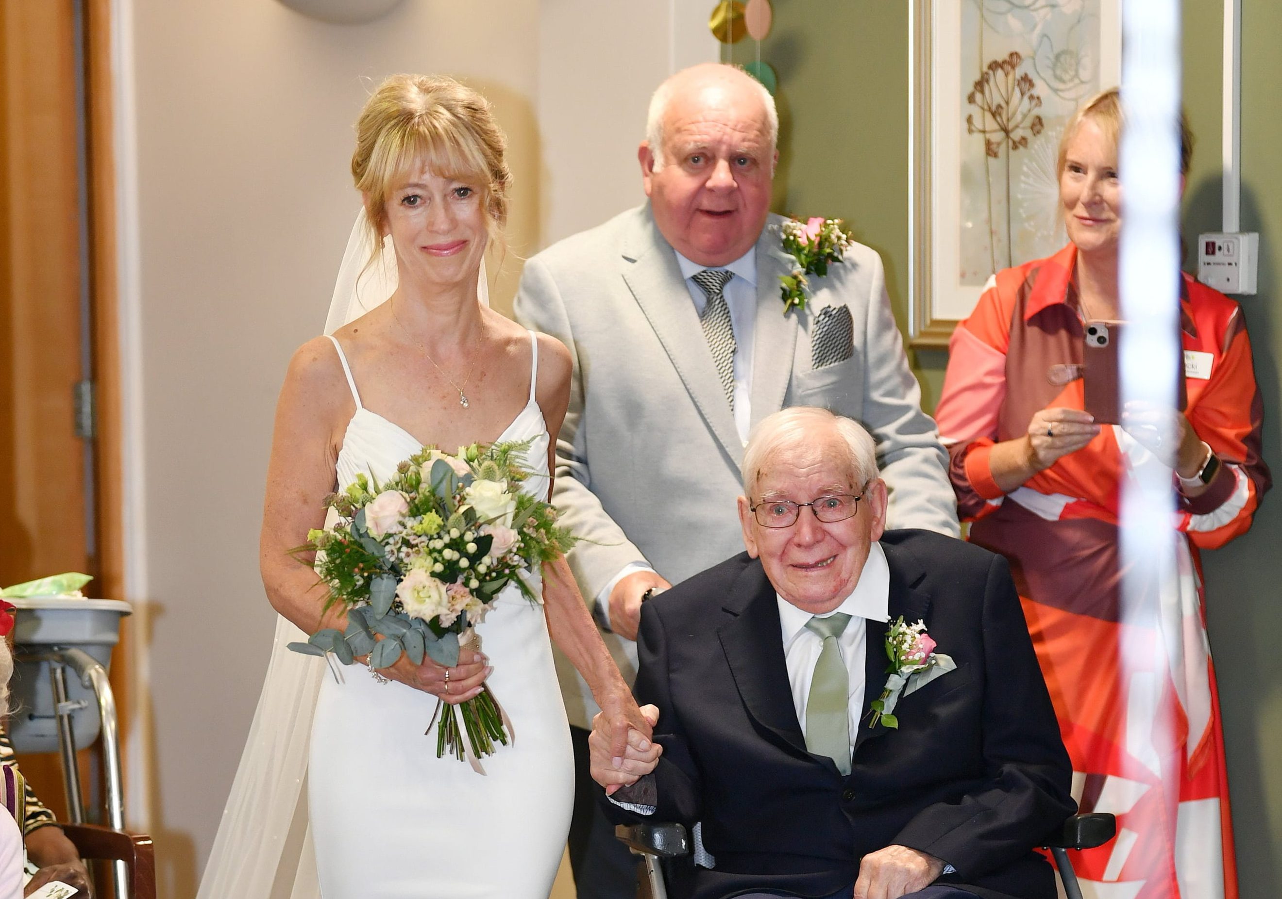 Fiona holds her father's hand as he walks her down the aisle