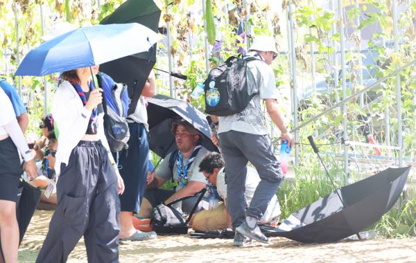 Scout members who participated in the 2023 World Scout Jamboree take rest in the scorching weather, Saturday. (Yonhap)