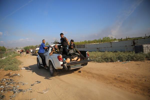
Palestinian militants drive back to the Gaza Strip with the body of an Israeli soldier on Saturday, Oct. 7, 2023. 