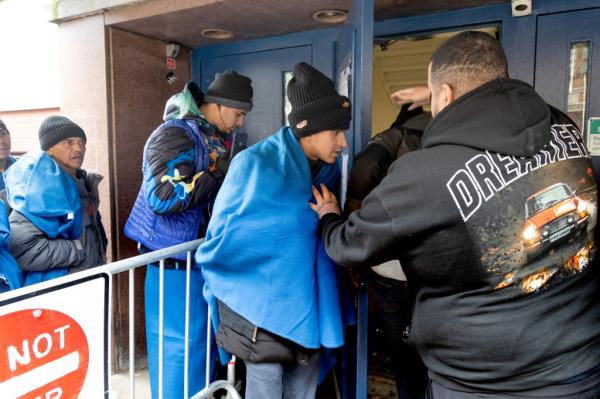 The scores of asylum seekers lining the sidewalk on East 7th Street near Tompkins Square Park are among the thousands forced to reapply for temporary housing after being booted under the administration's 30-day cap on shelter stays.