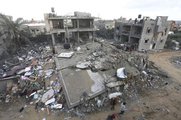 Palestinians gather in front of a building hit by an Israeli on the Gaza Strip at the Nusseirat refugee camp. Picture: AP Photo/Adel Hana Palestinians gather in front of a building hit by an Israeli on the Gaza Strip at the Nusseirat refugee camp. Picture: AP Photo/Adel Hana