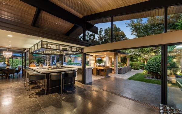 Jeremy Renner's luxurious Zen-style house in Los Angeles, featuring a large outdoor kitchen, expansive patio, and a covered area.