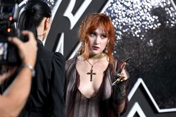 The 26-year-old initially turned away from photographers so she could primp her medieval outfit before posing for snaps.