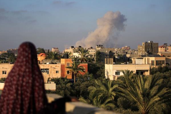 A Palestinian woman watches as smoke billows following an Israeli strike south of Gaza City, in the town of al-Zawaida in the central Gaza Strip, on June 11, 2024 amid the ongoing conflict between Israel and the Palestinian militant group Hamas.