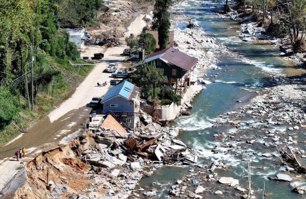 An aerial view of people standing near destroyed and damaged buildings in the aftermath of Hurricane Helene flooding on October 8, 2024 in Bat Cave, North Carolina. Bat Cave was particularly hard hit by flooding. Recovery efforts continue as the death toll has risen to over 230 while the powerful Hurricane Milton is on track to make landfall in Florida. (Photo by Mario Tama/Getty Images)