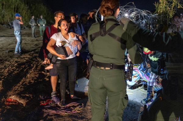 A family waits to be processed by US Border Patrol agents after they crossed the U.S.-Mexico border at Eagle Pass, Texas