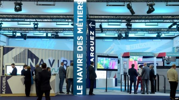 FILE - People visit the Navire des Metiers stand at Euronaval 2018, a naval defense equipment fair, in Le Bourget, near Paris, Oct. 23, 2018. 