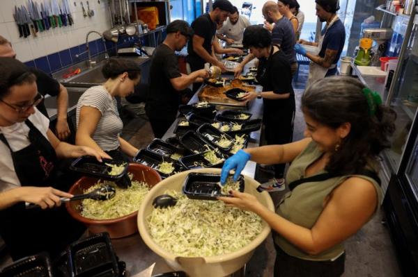 Josephine Abou Abdo, one of the founders of non-profit organisation Nation Station, prepares meals with volunteers for people displaced due to Israeli bombardment, in Beirut, Lebanon