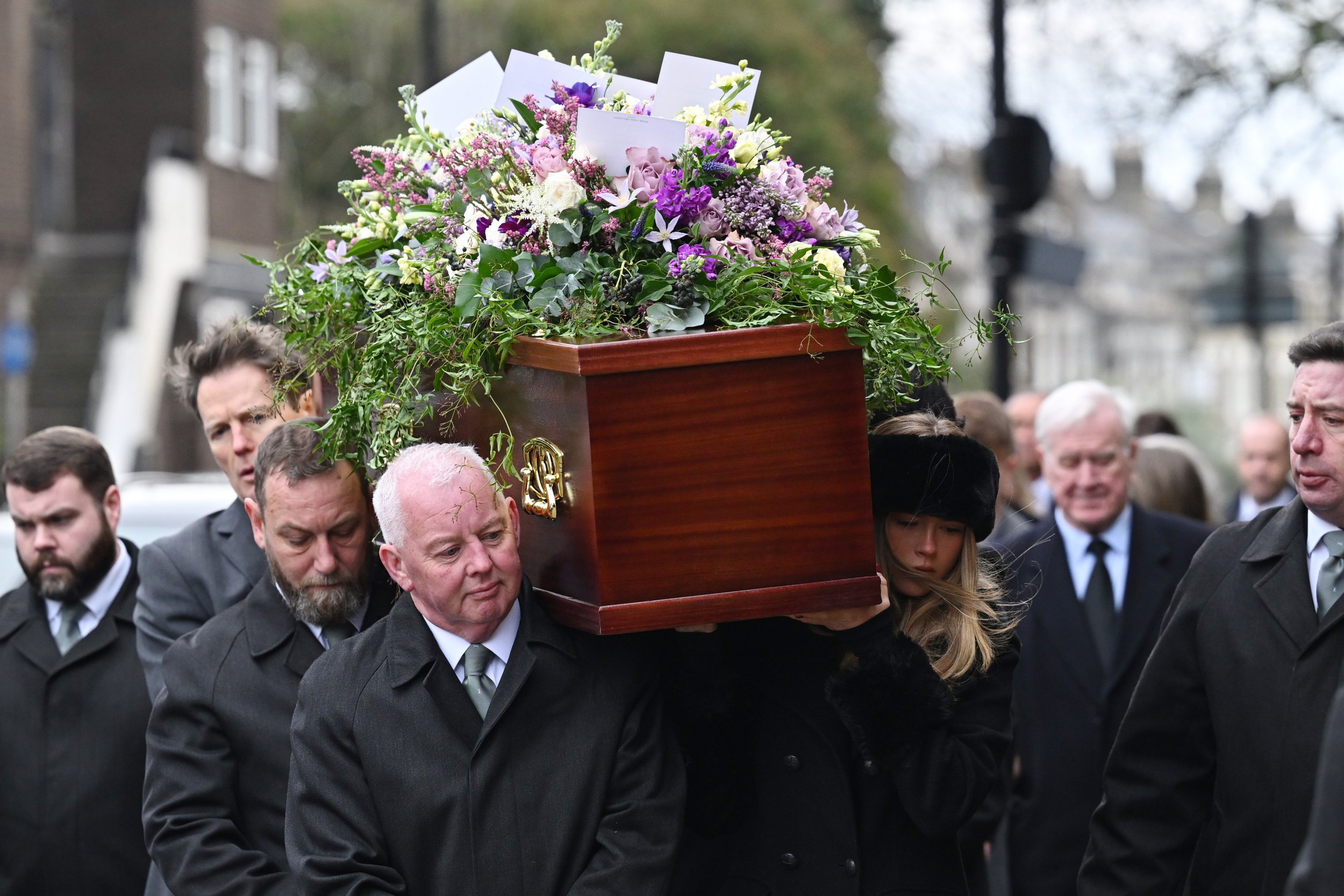 Darcey Draper carries her father's coffin as she attends the funeral of Derek Draper 