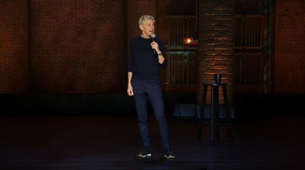 Ellen DeGeneres, holding a microphone, embracing her age without Botox or fillers, in a scene from 'For Your Approval' on Netflix