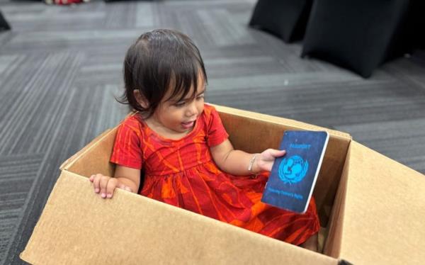 Pepe plays while adults discuss child rights in Samoa.
