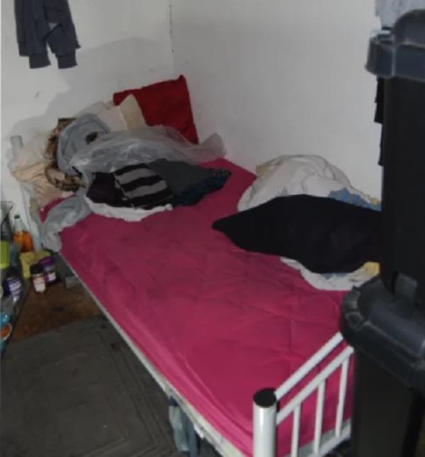 A small cot covered with items.