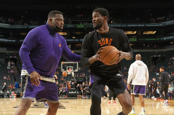 New Knicks assistant coach Mark Bryant helps Deandre Ayton #22 of the Phoenix Suns warm up before the game against the Dallas Mavericks in 2022.