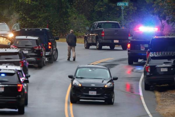 An officer walks up Precinct Street in Lakeville toward Pickens Street where a shooting involving an officer occurredd. The pickup truck involved in the shooting can be see next to the street sign.