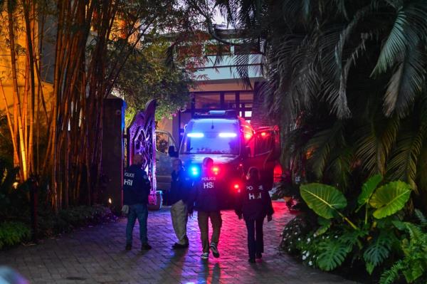 Homeland Security Investigation agents are seen at the entrance of US producer and musician Sean "Diddy" Combs's home.