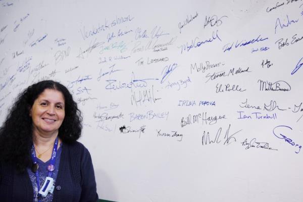 ORNL's Hassina Bilheux stands before names of staff who have worked on the Spallation Neutron Source's latest addition, the Versatile Neutron Imaging Instrument, or VENUS.