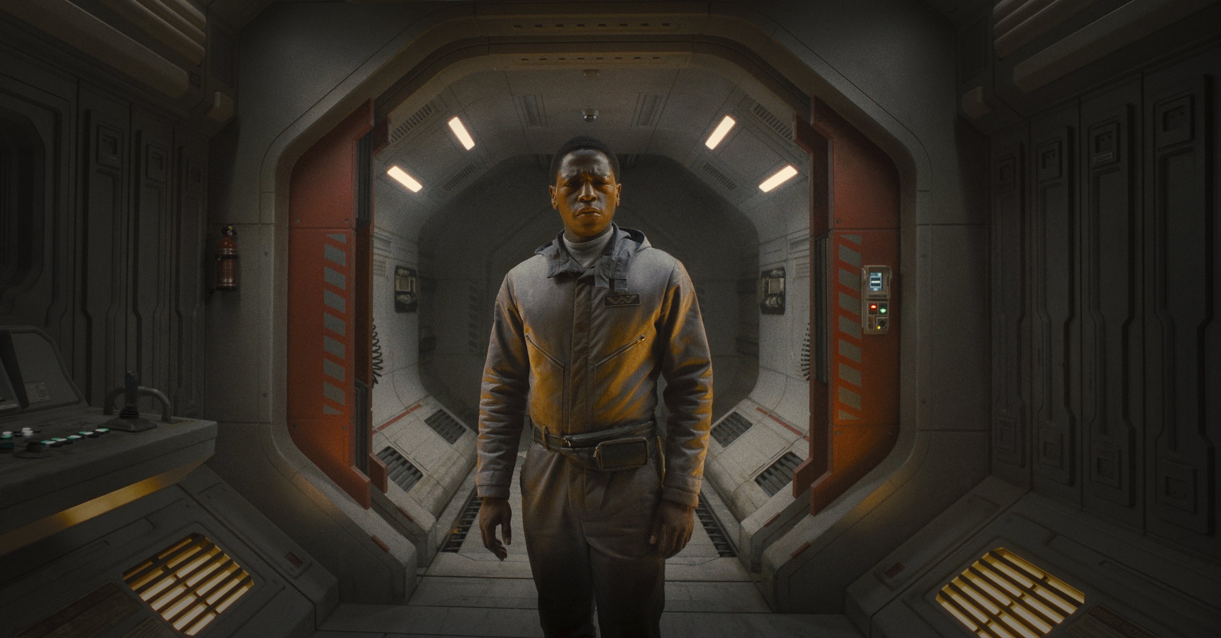 David Jonsson as synthetic Andy stands in a corridor of a space station, frowning, in a scene from Alien: Romulus