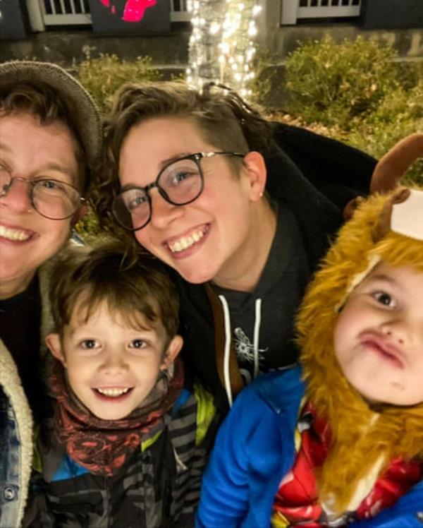 Two adults and two children smiling.