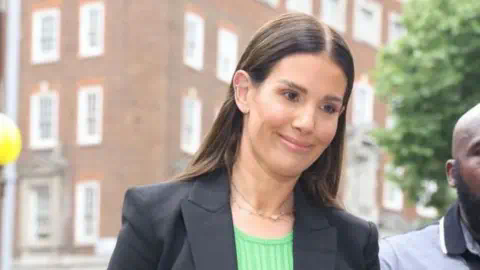 Getty Images Rebekah Vardy in a dark jacket, seen at her libel case in 2022