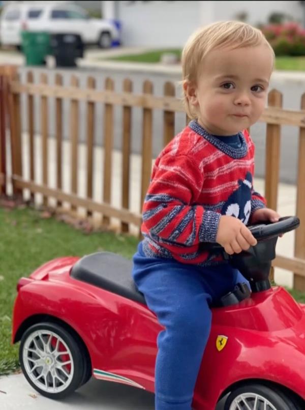 Nico is pictured riding a toy car.