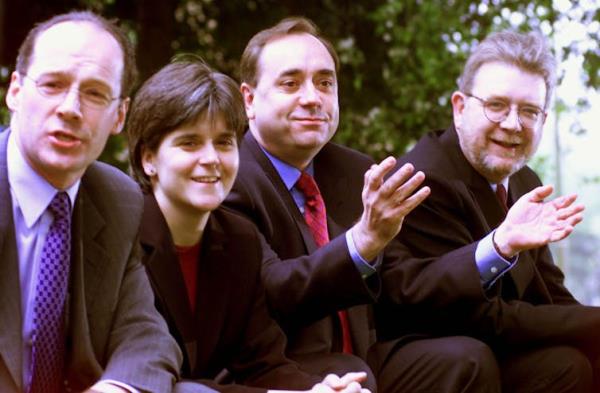 An old photo of John Swinney, Nicola Sturgeon, Alex Salmond and Mike Russell seated, smiling, wearing suits.