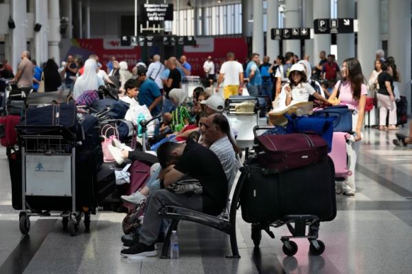 Passengers whose flights were cancelled, wait at the departure terminal of Rafik Hariri International Airport