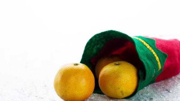 green and red christmas stocking with oranges in it