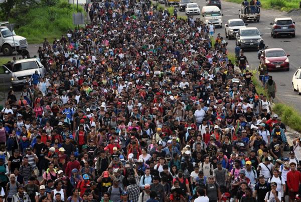 Thousands of migrants in a caravan walking on a road in southern Mexico
