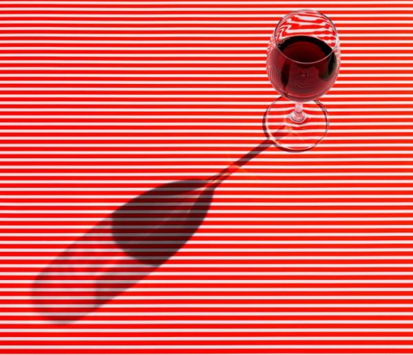 High angle view of red wine served on striped table