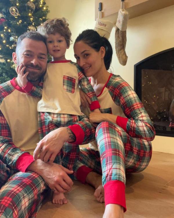 Nikki Bella poses with husband Artem Chigvintsev and their son Matteo.