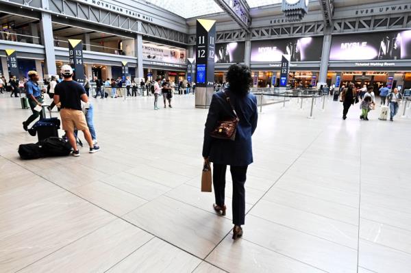 A photo of Rawles walking in Penn Station. The photo is taken with her back to the camera.