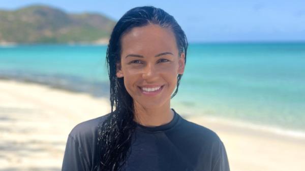 A young Indigenous woman smiles on a tropical beach